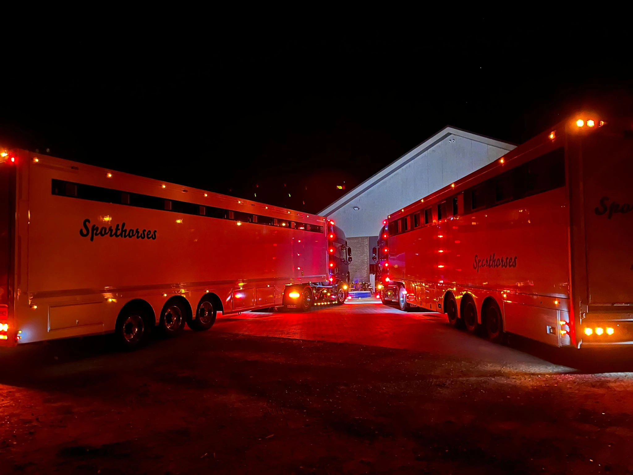 Horse transport trucks staged at night before a competition departure